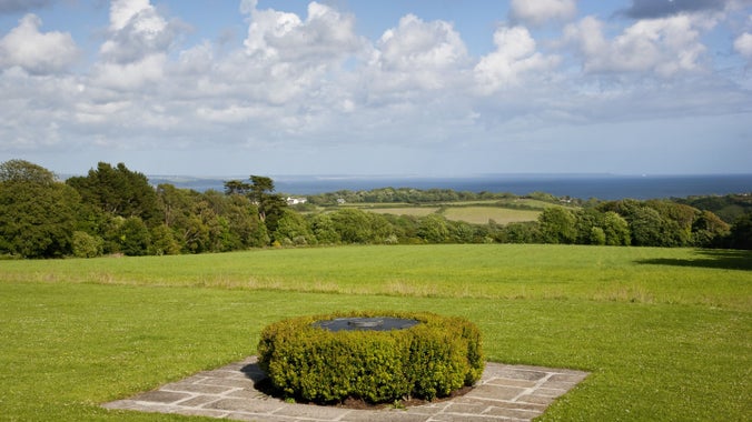 A slate viewfinder surrounded by box hedging, with sweeping views across fields to the sea beyond.